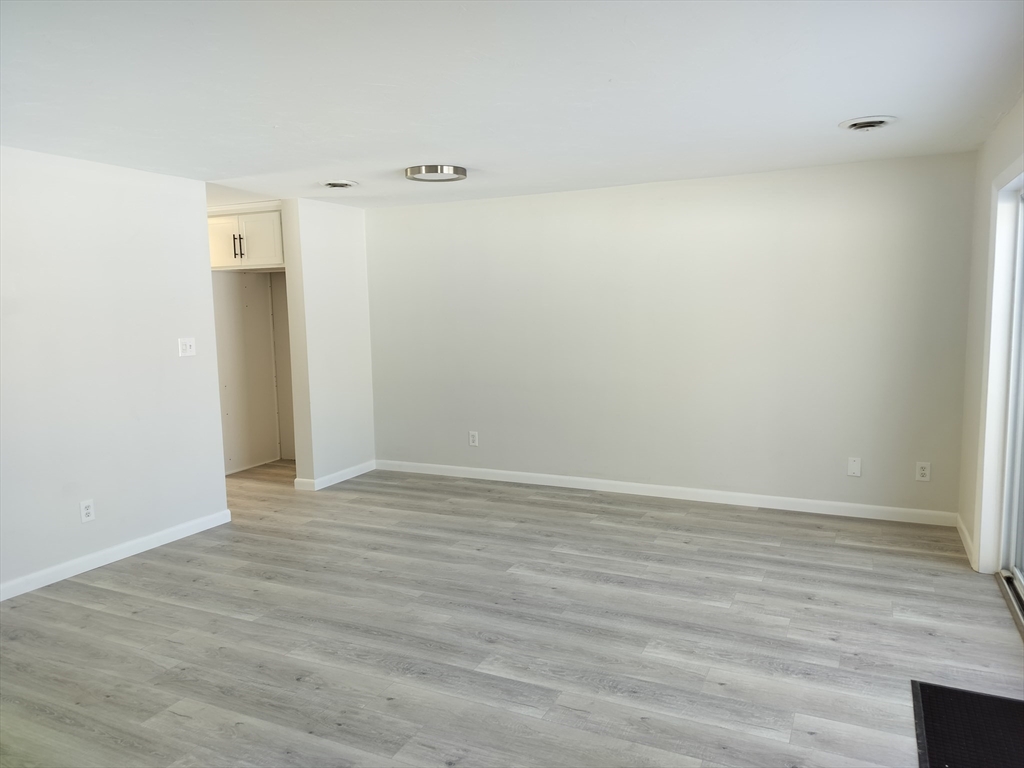 75 Warren Street West, Unit 16 Raynham, MA 02767 - Photo 11 of 22 a view of an empty room with wooden floor and closet