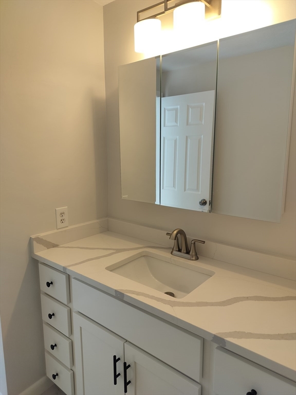 75 Warren Street West, Unit 16 Raynham, MA 02767 - Photo 6 of 22 a bathroom with a sink and a mirror