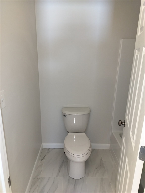 75 Warren Street West, Unit 16 Raynham, MA 02767 - Photo 7 of 22 a white toilet sitting next to a sink