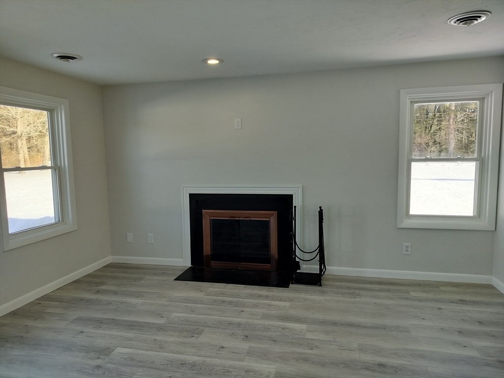 75 Warren Street West, Unit 16 Raynham, MA 02767 - Photo 10 of 22 a view of empty room with a fireplace and wooden floor