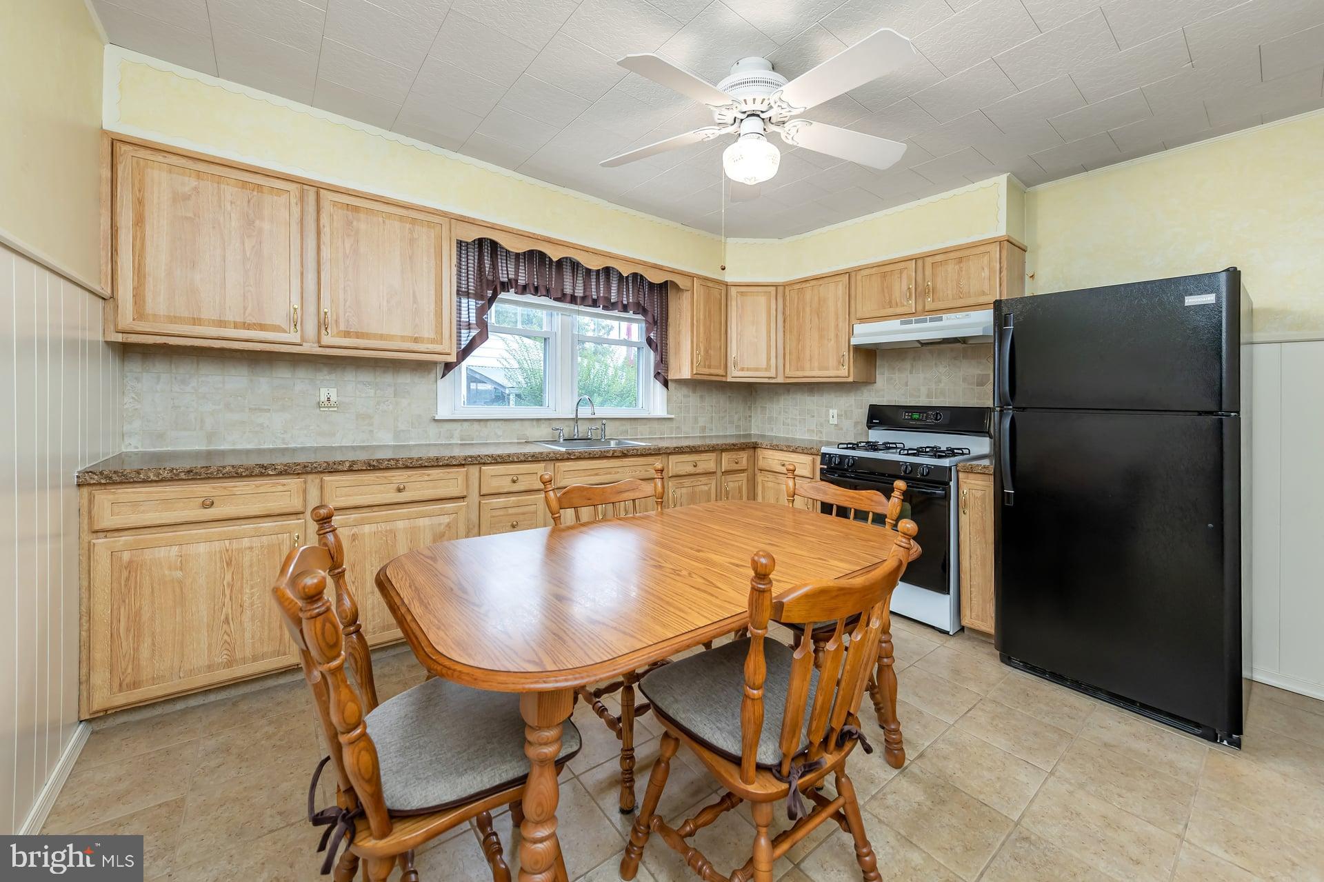 2008 Sycamore Street Haddon Heights, NJ 08035 - Photo 7 of 17 a kitchen with stainless steel appliances granite countertop a dining table chairs refrigerator and cabinets