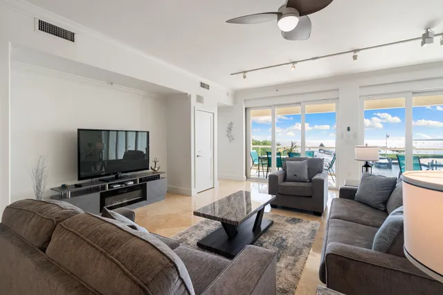 a living room with furniture a flat screen tv and a large window