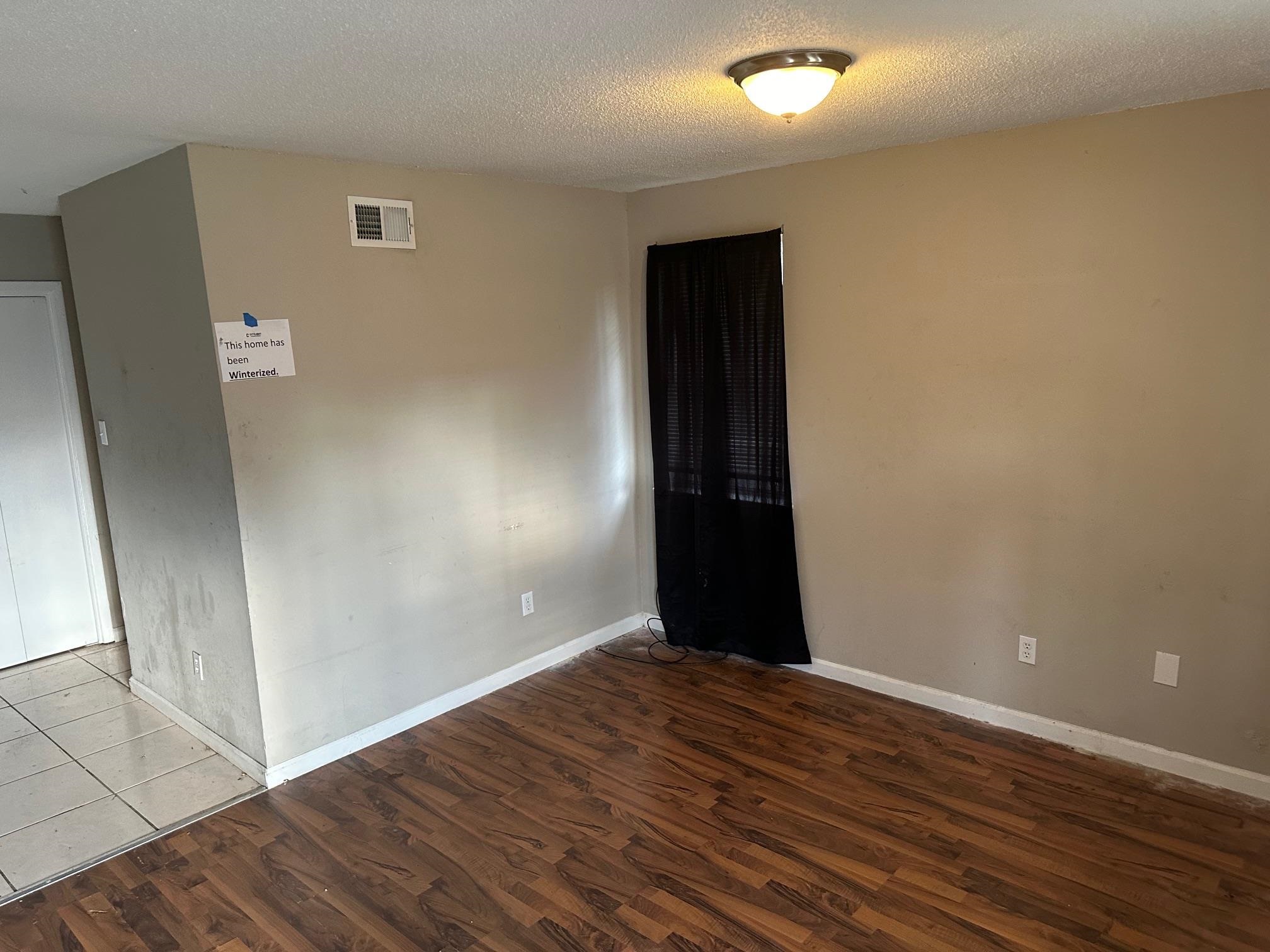 4423 Sumners Wells Road Memphis, TN 38118 - Photo 2 of 8 Empty room featuring a textured ceiling and hardwood / wood-style flooring