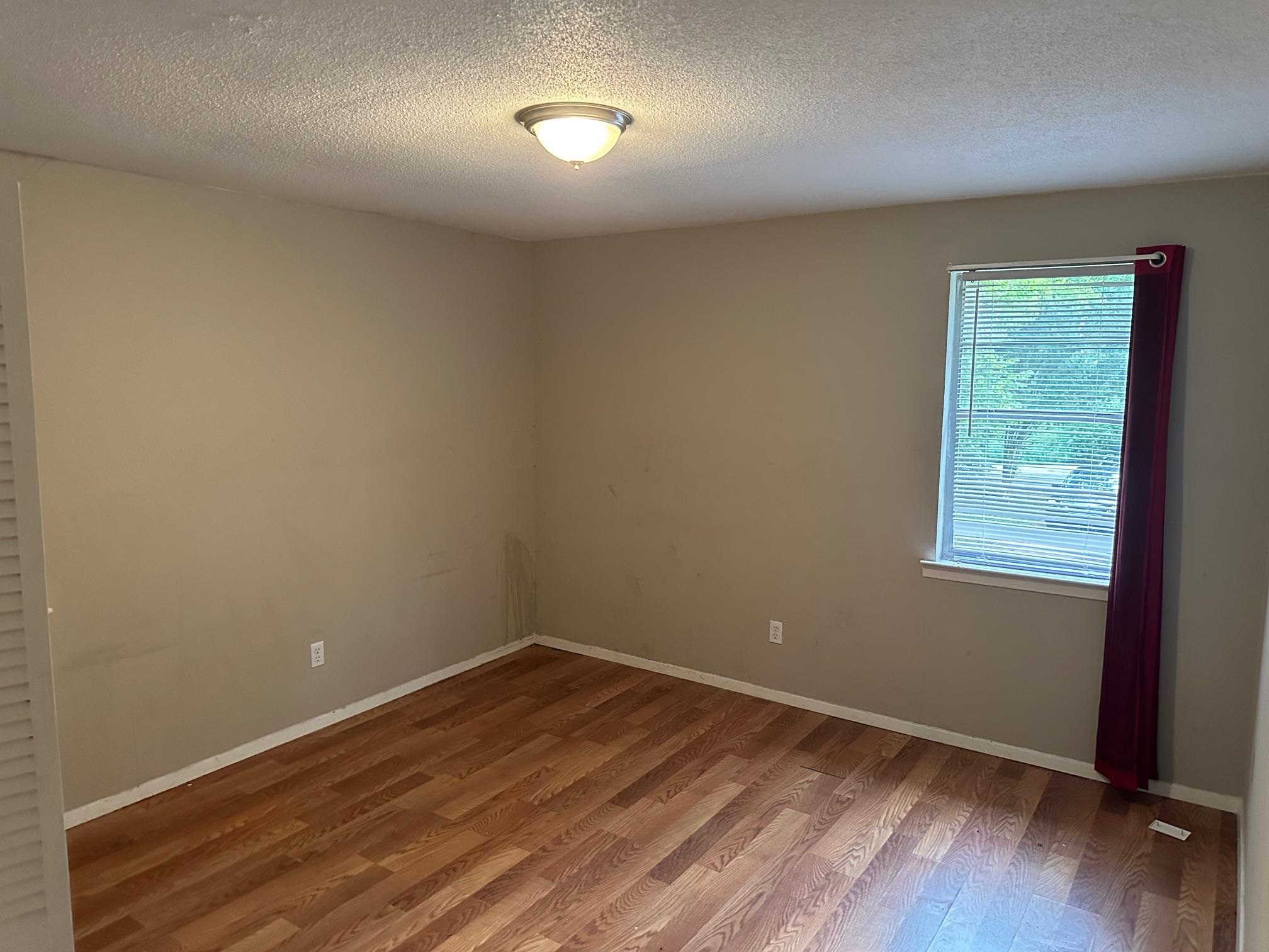 4423 Sumners Wells Road Memphis, TN 38118 - Photo 4 of 8 Unfurnished room with a textured ceiling and hardwood / wood-style flooring