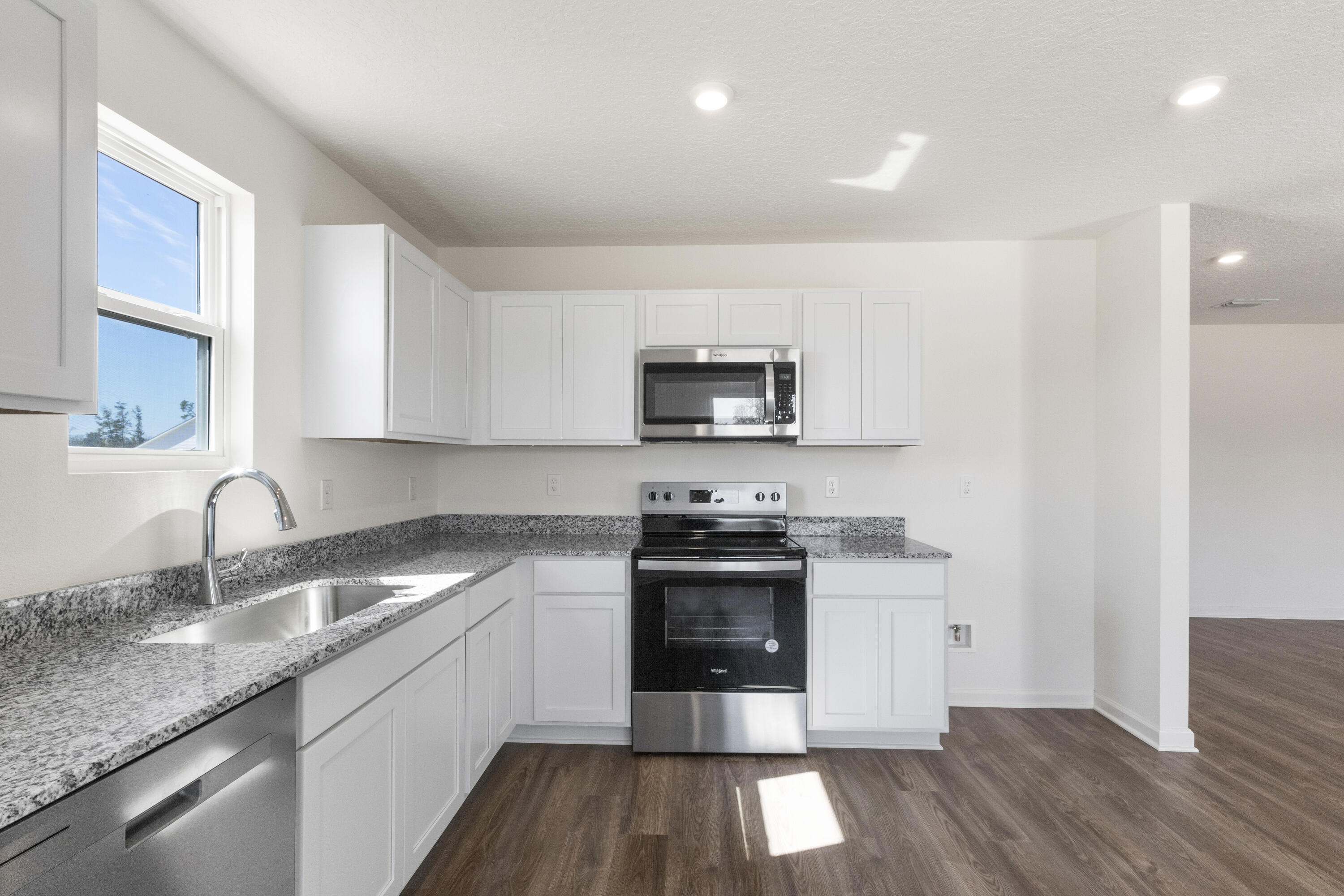 291 Cat Island Road DeFuniak Springs, FL 32433 - Photo 4 of 18 a kitchen with granite countertop a sink cabinets and stainless steel appliances