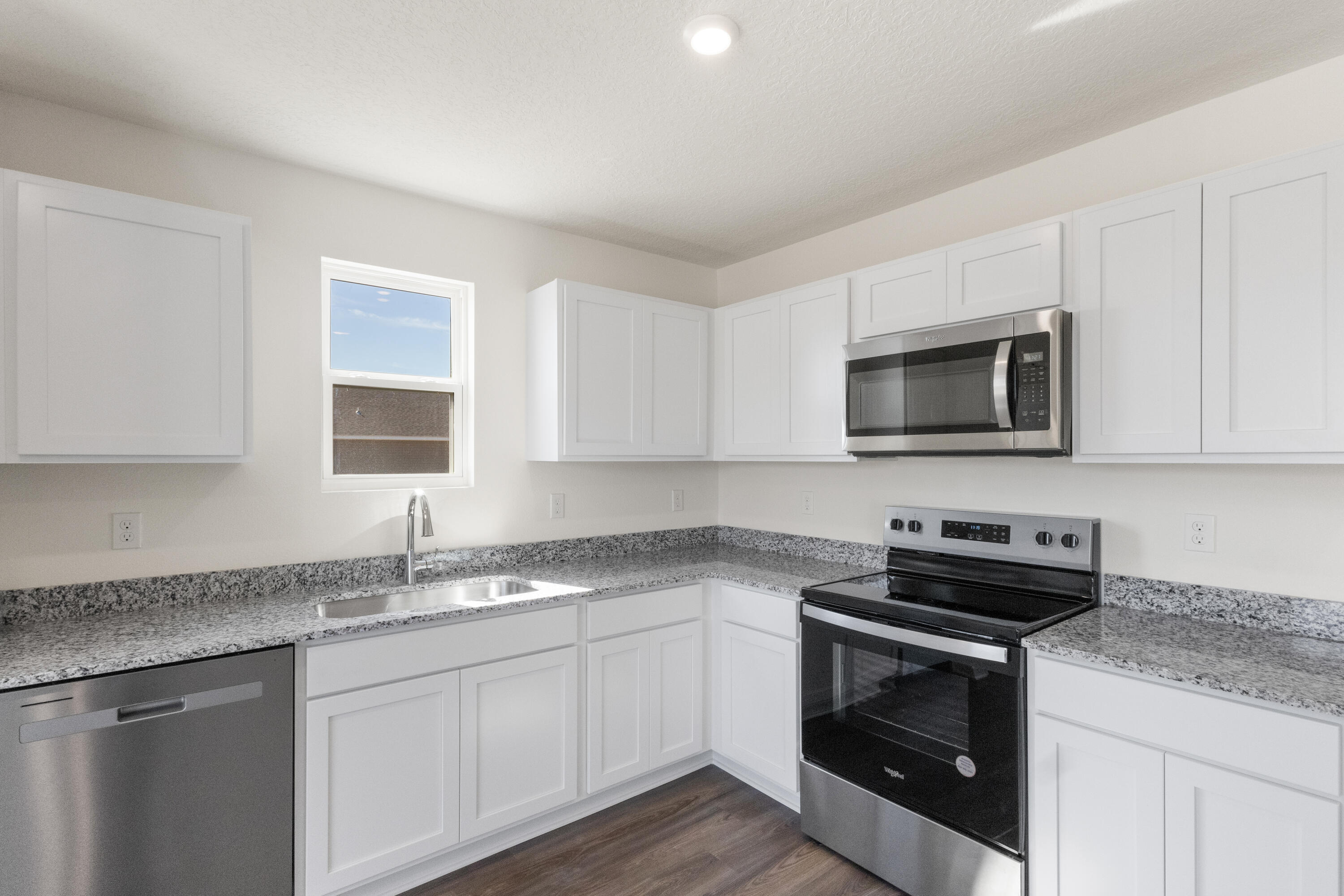 291 Cat Island Road DeFuniak Springs, FL 32433 - Photo 5 of 18 a kitchen with granite countertop a sink dishwasher a stove and a microwave oven with cabinets