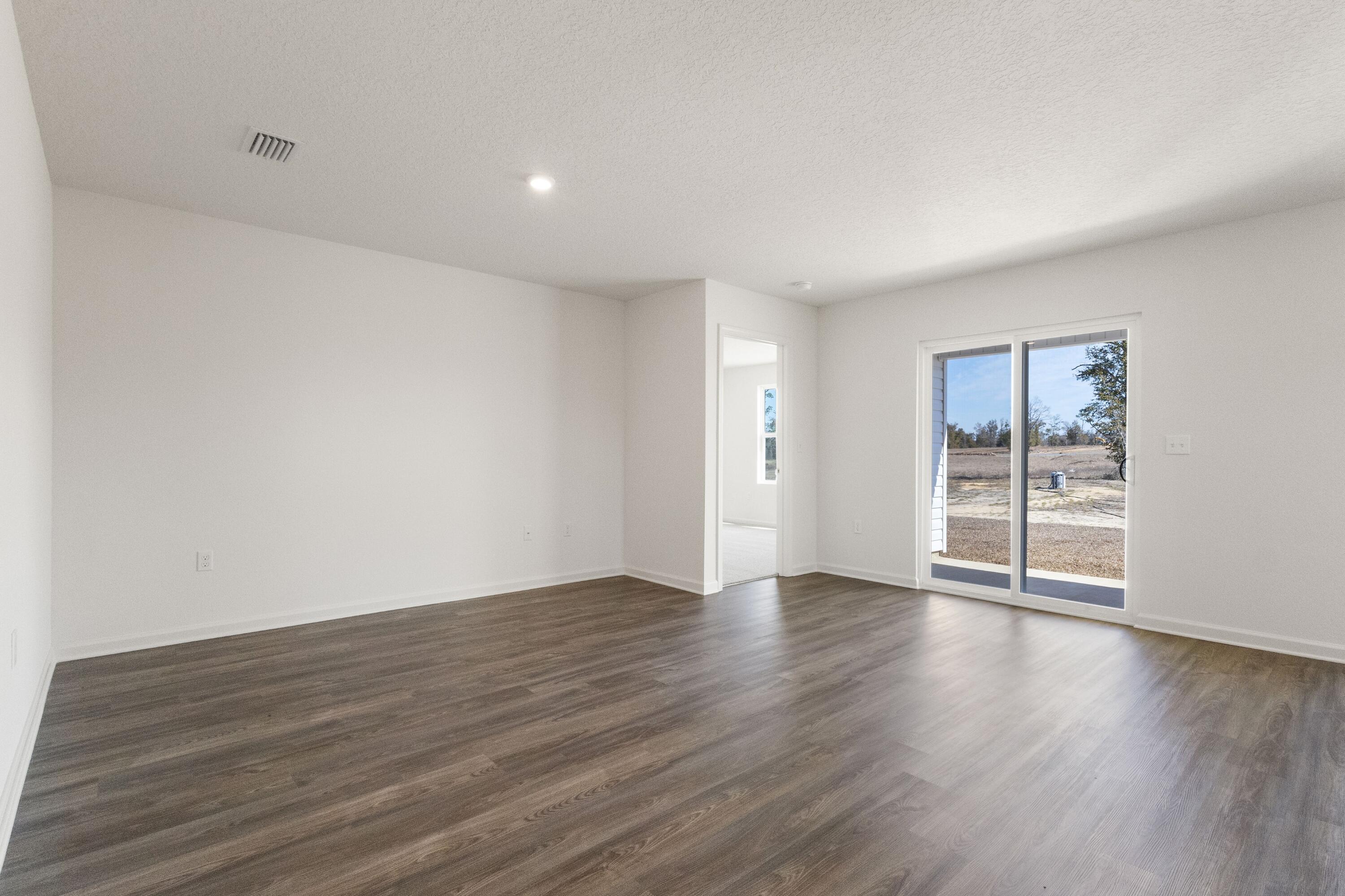 291 Cat Island Road DeFuniak Springs, FL 32433 - Photo 7 of 18 a view of an empty room with wooden floor and a window