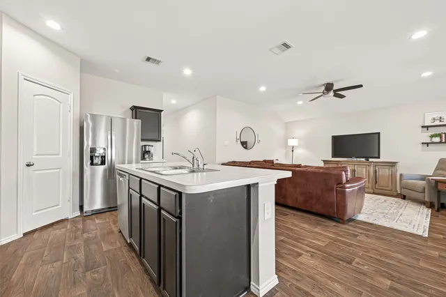 a kitchen with a sink and wooden floor