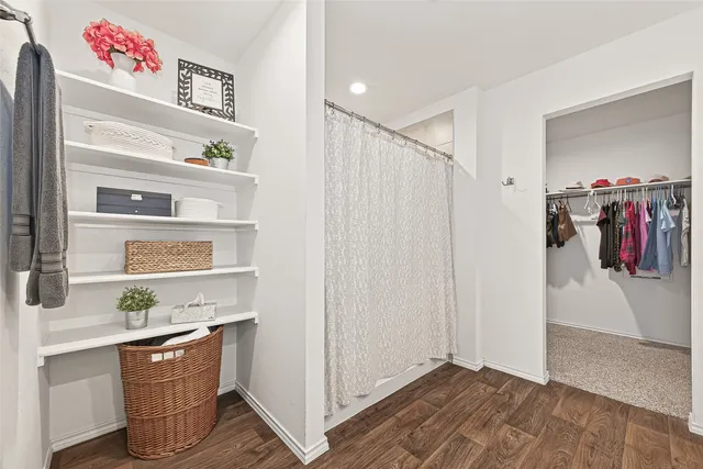 a hallway with white cabinets and wooden floor