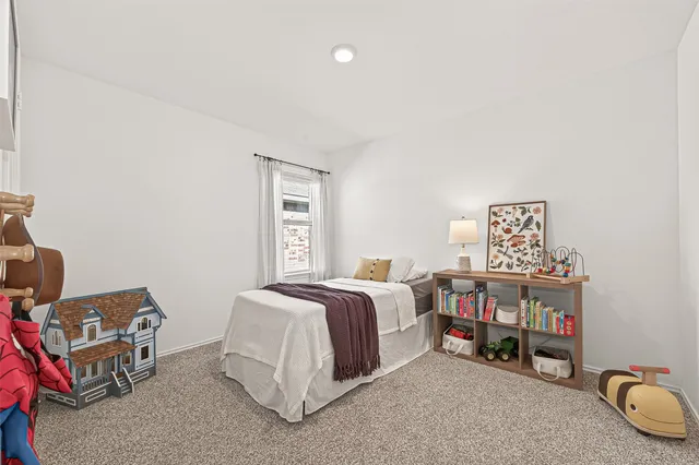 a bed room with a bed and a chair