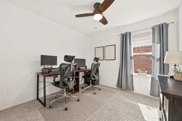 a view of a workspace with furniture and a window