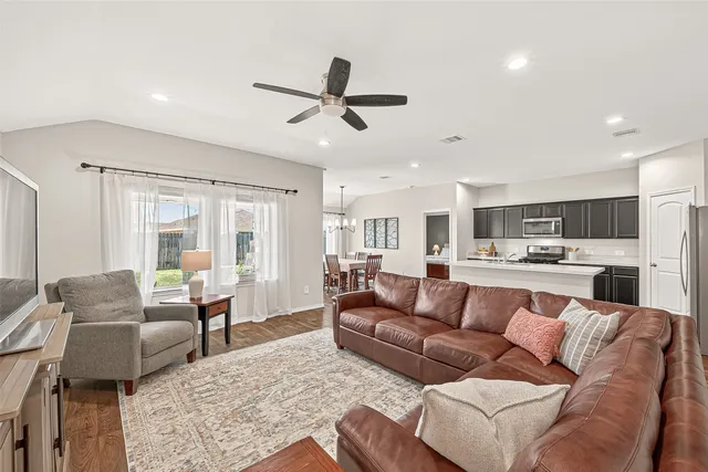 a living room with furniture kitchen view and a window