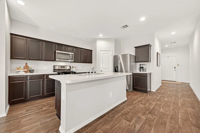 a kitchen with stainless steel appliances a refrigerator stove microwave and sink