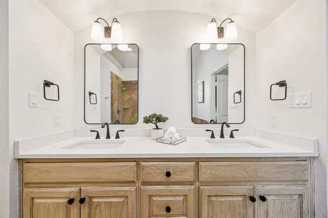 a bathroom with double vanity sinks and a mirror