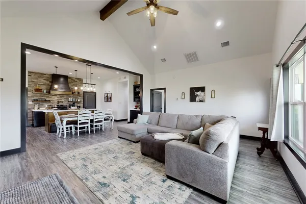 a view of a dining room with furniture a chandelier and wooden floor