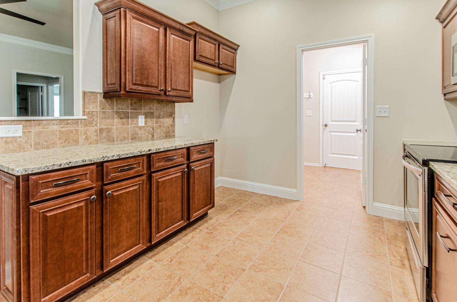9105 Rochester Avenue Lubbock, TX 79424 - Photo 24 of 24 a kitchen with stainless steel appliances granite countertop a stove a sink and a refrigerator with wooden cabinets