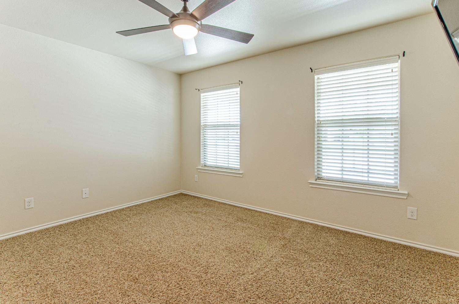 9105 Rochester Avenue Lubbock, TX 79424 - Photo 7 of 24 an empty room with a window and a fan