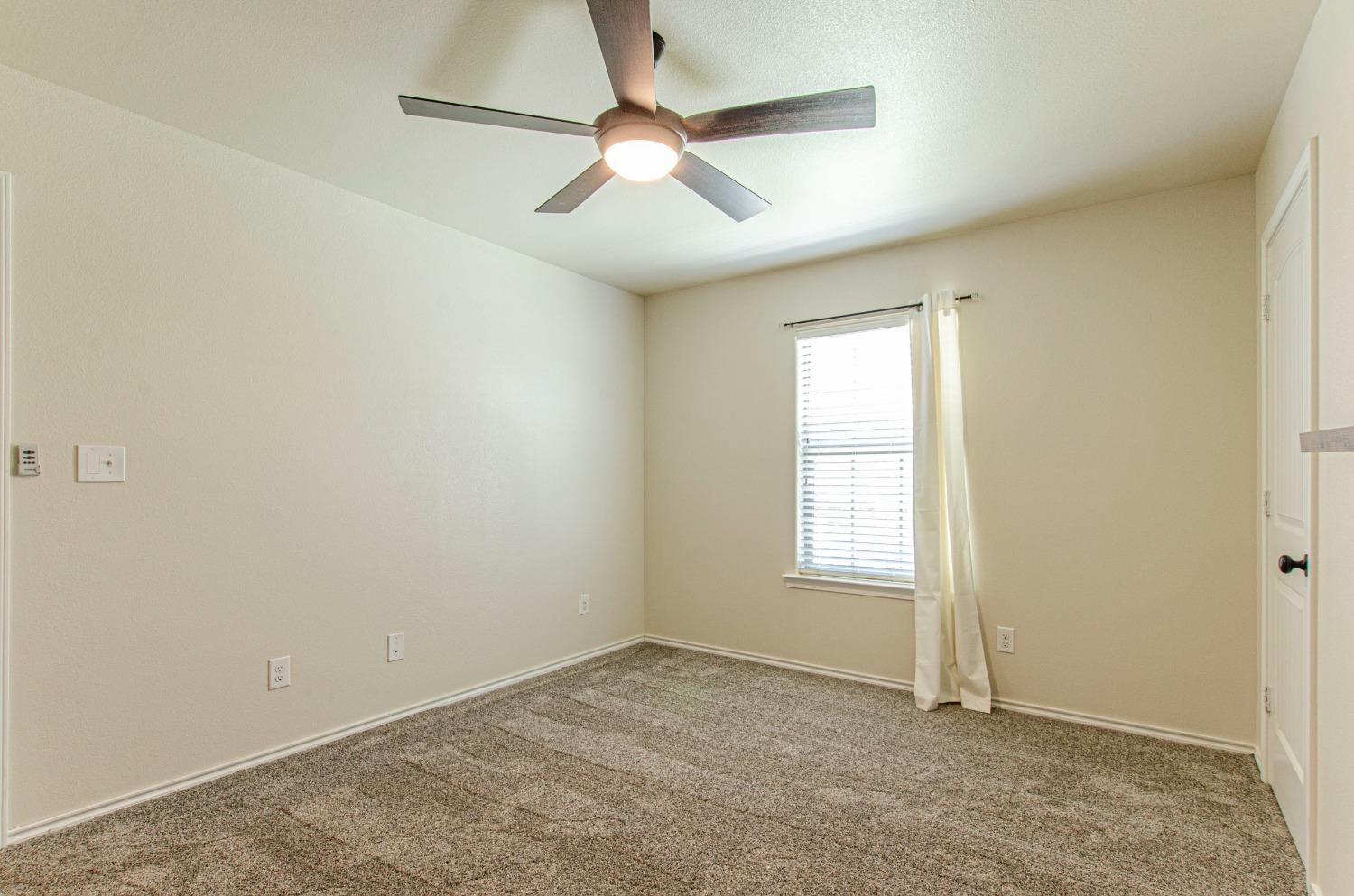 9105 Rochester Avenue Lubbock, TX 79424 - Photo 8 of 24 an empty room with windows and fan