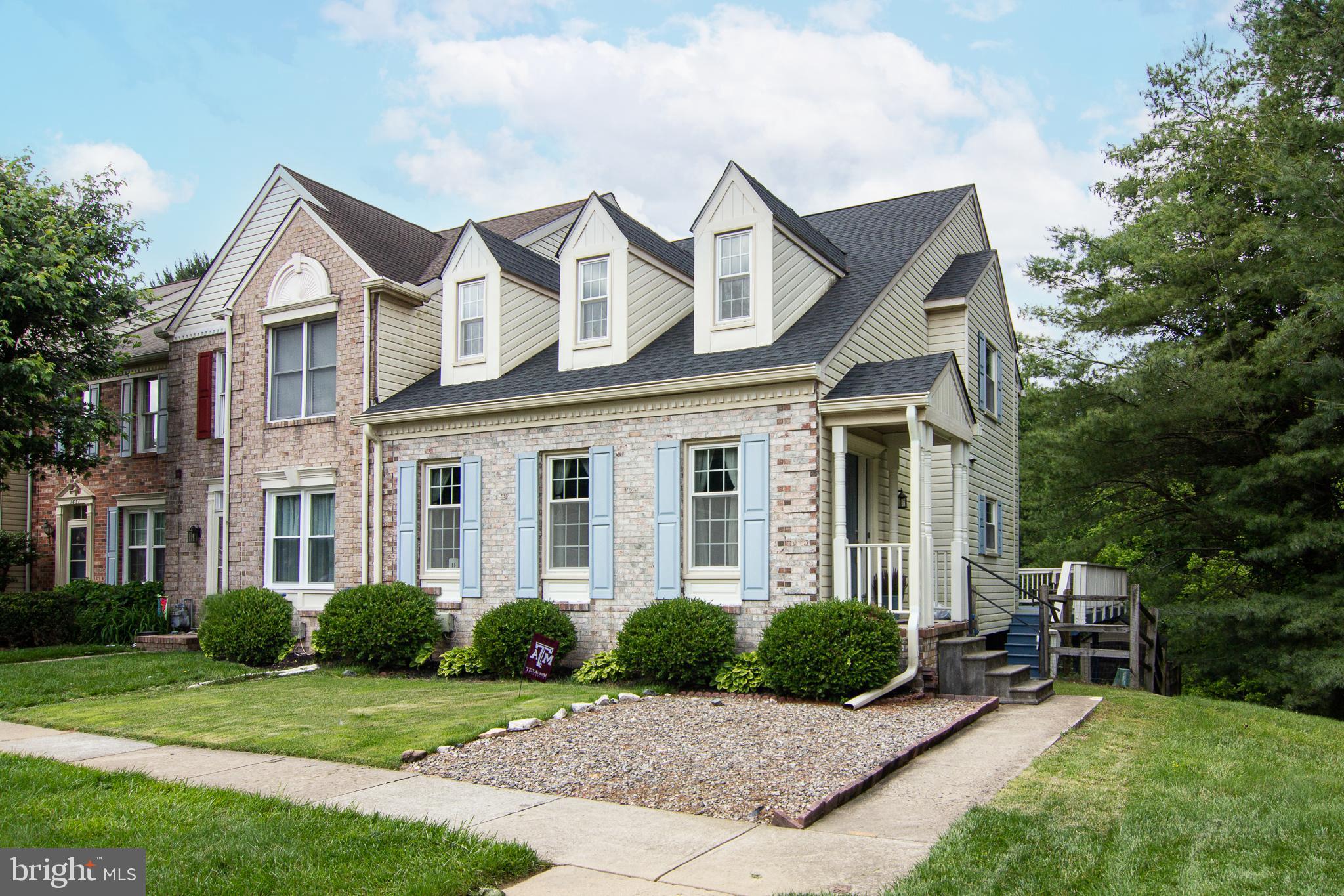 a front view of a house with yard and green space