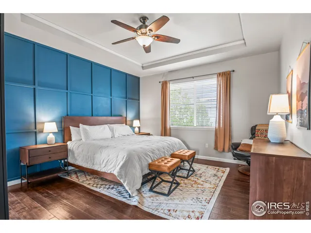 a bedroom with a bed a chair and a large window