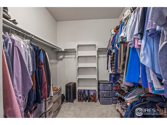 a view of walk in closet with clothes and shoes