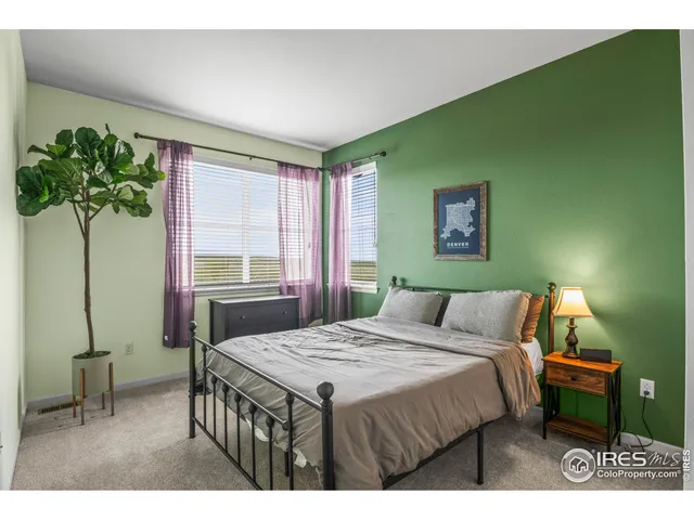 a bedroom with a bed table and a potted plant