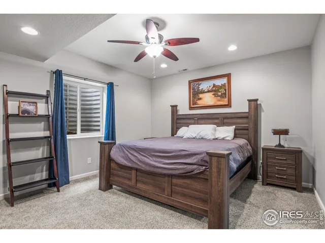 a bedroom with a bed and a ceiling fan