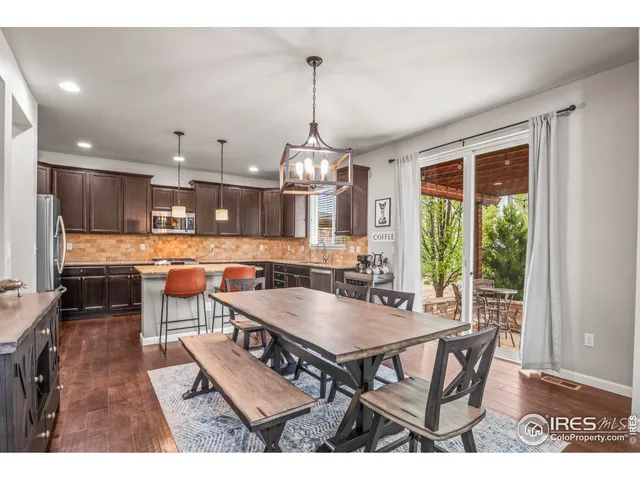 a dining room with furniture a chandelier and wooden floor
