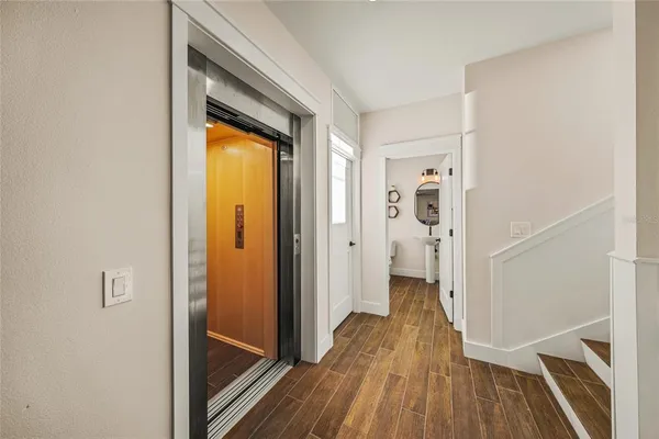 a view of a hallway with wooden floor and staircase
