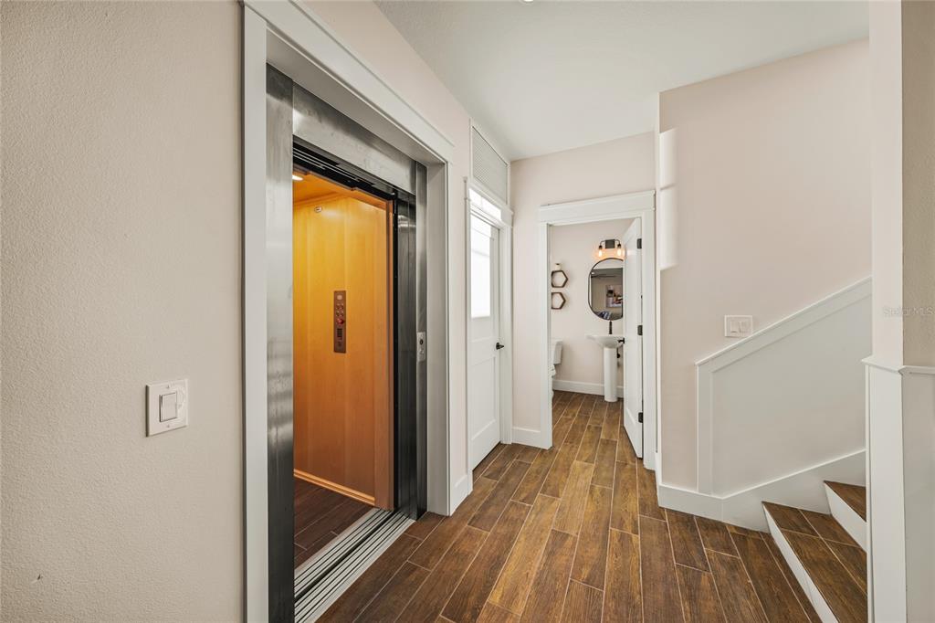 6910 Midnight Pass Road, Unit A Sarasota, FL 34242 - Photo 12 of 40 a view of a hallway with wooden floor and staircase