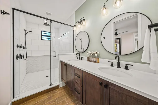 a bathroom with a double vanity sink mirror and shower