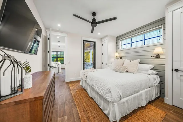 a bedroom with a large bed a flat tv screen and a dresser