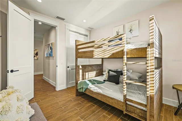 a bedroom with a bed and wooden floor