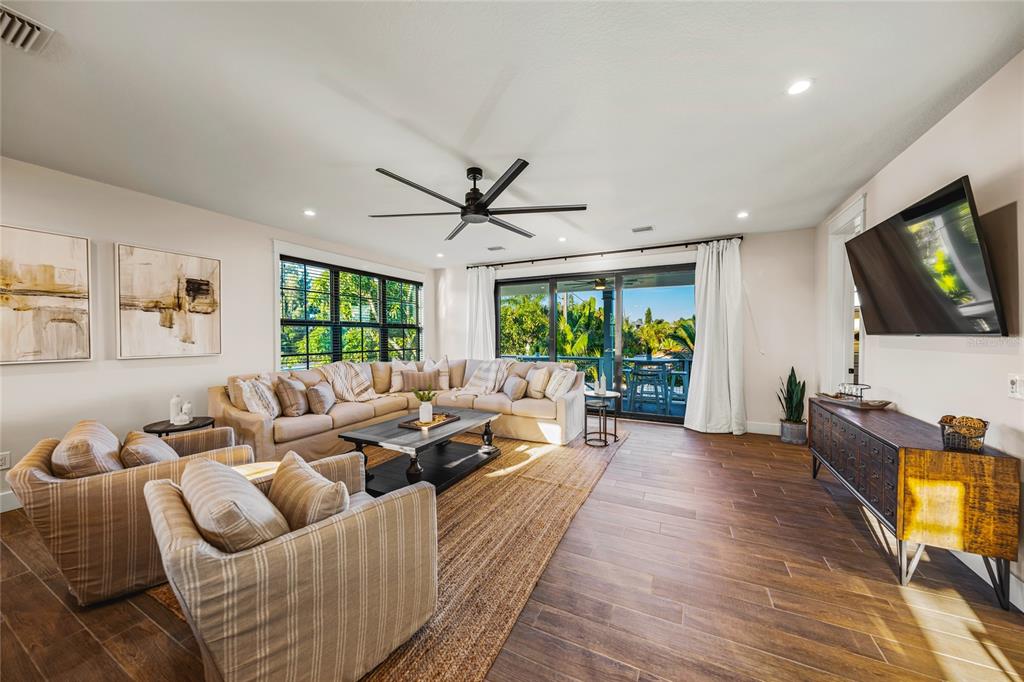6910 Midnight Pass Road, Unit A Sarasota, FL 34242 - Photo 10 of 40 a living room with furniture and a flat screen tv