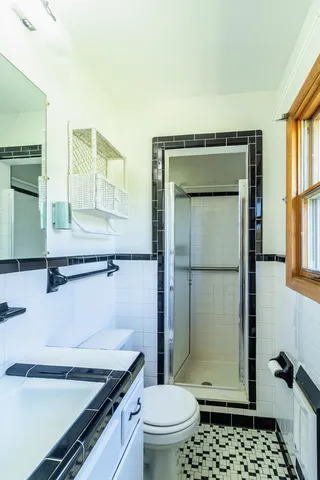 a bathroom with a granite countertop sink toilet and shower