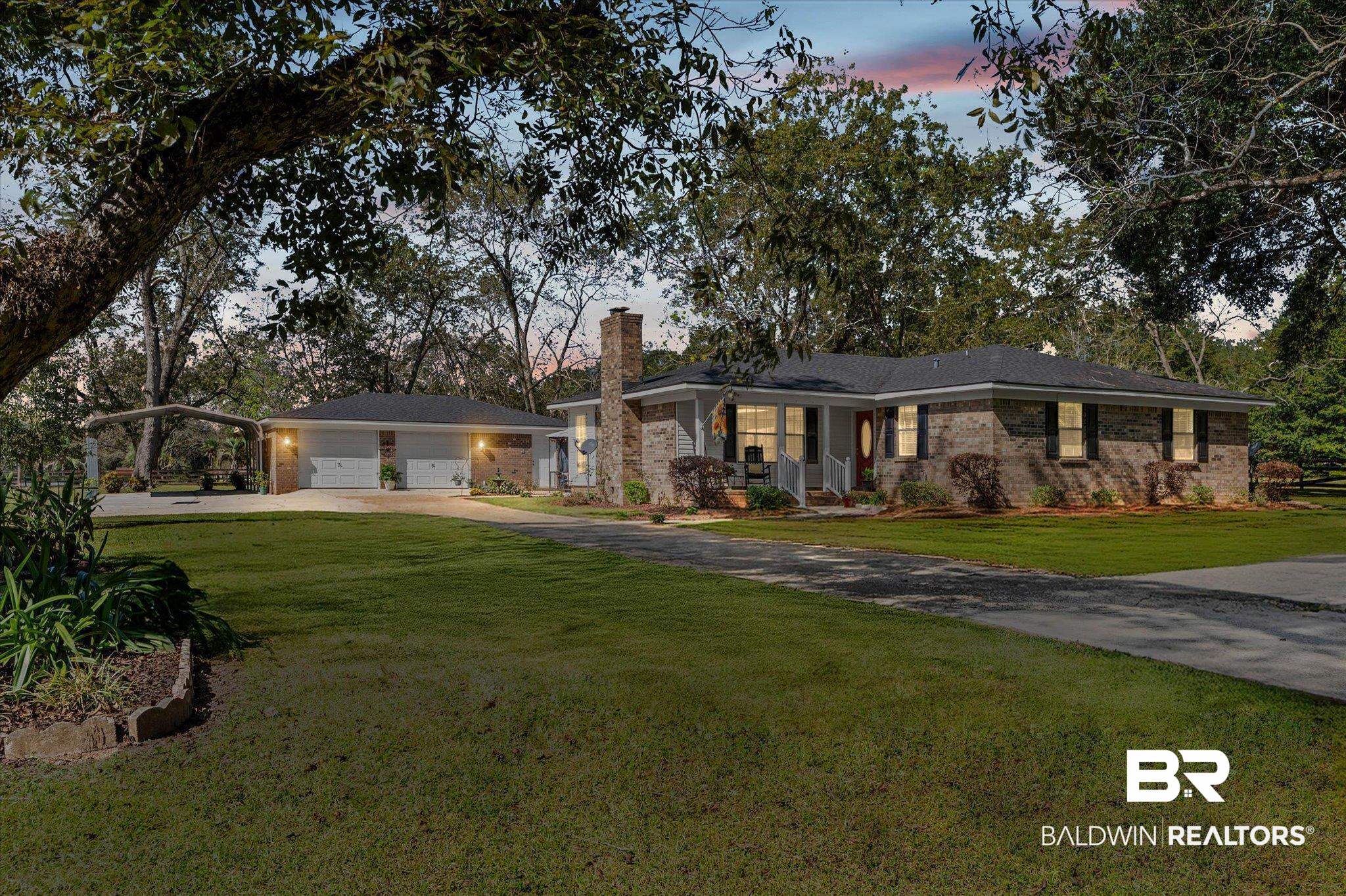 8090 Murray Hill Road Irvington, AL 36544 - Photo 39 of 40 Ranch-style home with a chimney, concrete driveway, a front lawn, and a garage