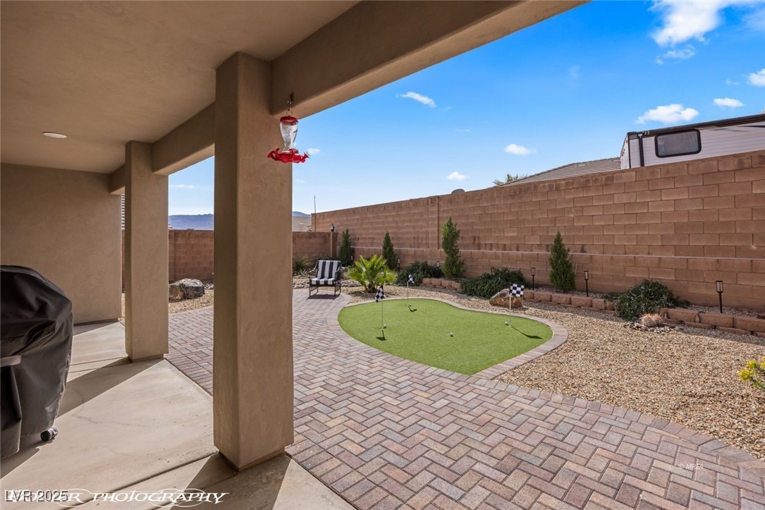 942 Shadow Hawk Ridge Mesquite, NV 89027 - Photo 46 of 67 View of patio / terrace featuring an area to practice putting, a fenced backyard, and grilling area