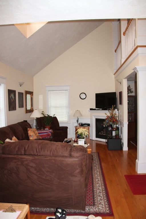 3 Ellsworth Village Road, Unit 2 Acton, MA 01720 - Photo 5 of 25 a living room with furniture a fireplace and a flat screen tv