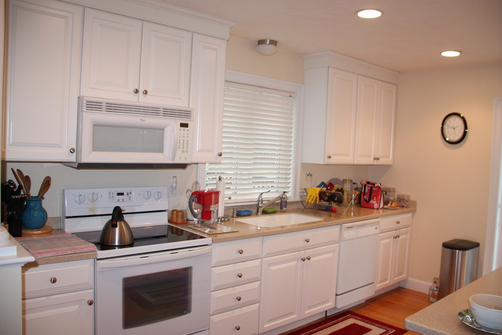 3 Ellsworth Village Road, Unit 2 Acton, MA 01720 - Photo 8 of 25 a kitchen with white cabinets and white appliances
