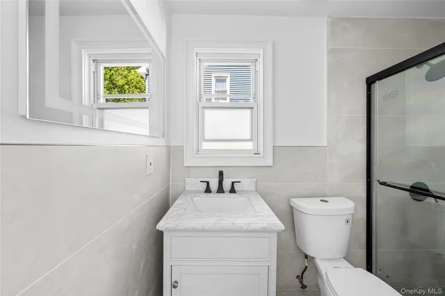 a bathroom with a toilet sink and mirror
