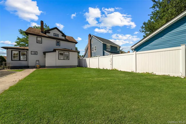 a view of a house with a big yard and large tree