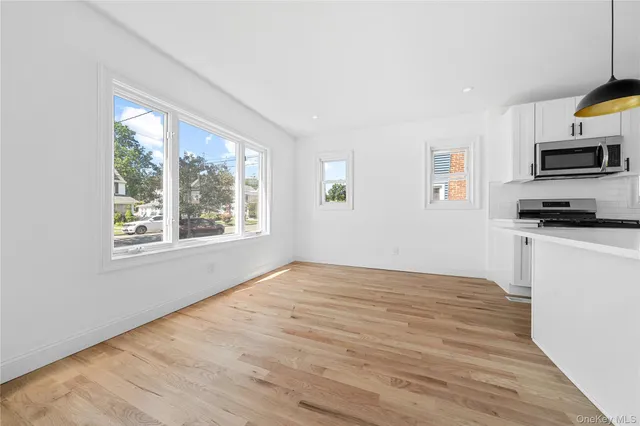 a view of a kitchen with wooden floor and a window