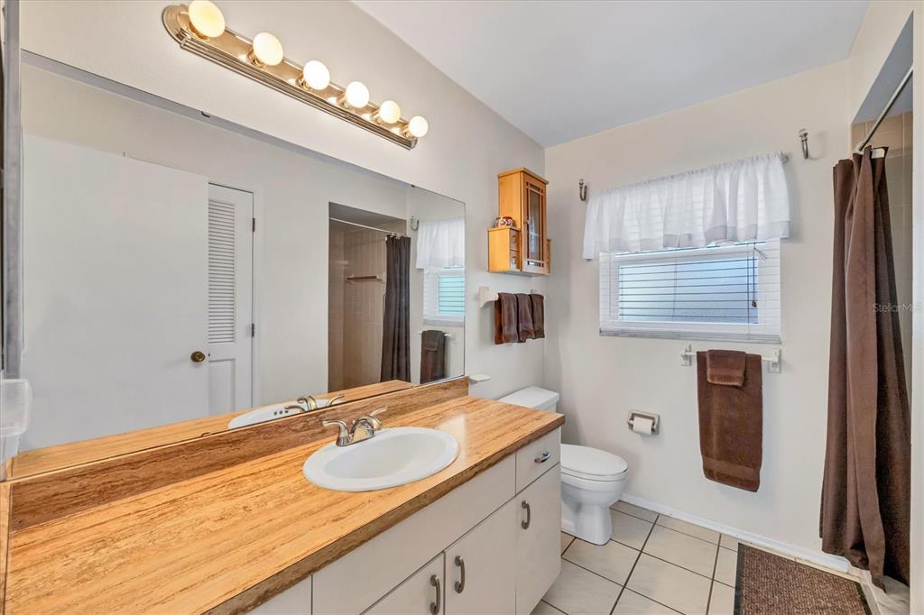 571 Morningside Road Venice, FL 34293 - Photo 13 of 36 a bathroom with a granite countertop sink a large mirror and a toilet