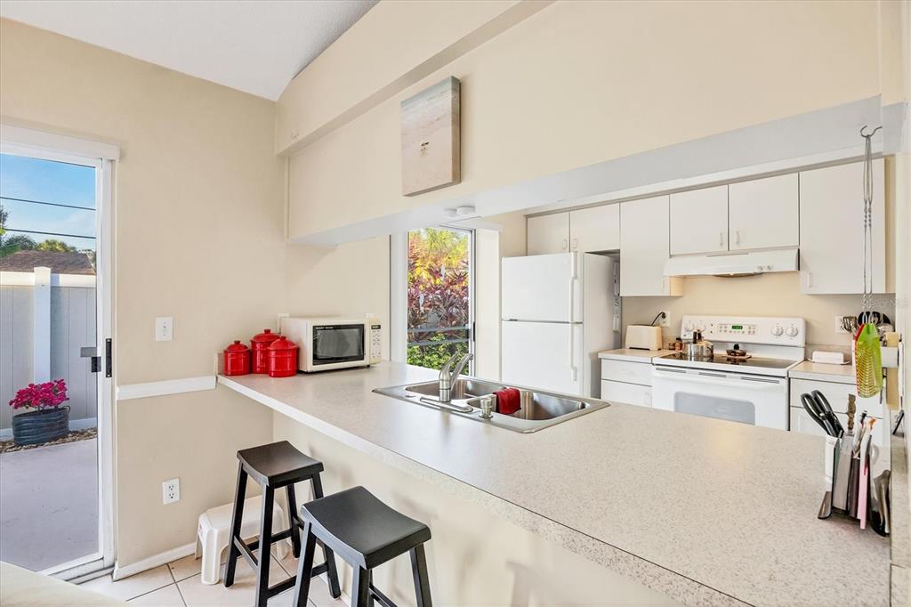 571 Morningside Road Venice, FL 34293 - Photo 7 of 36 a kitchen with a refrigerator a stove a sink dishwasher and white cabinets with wooden floor