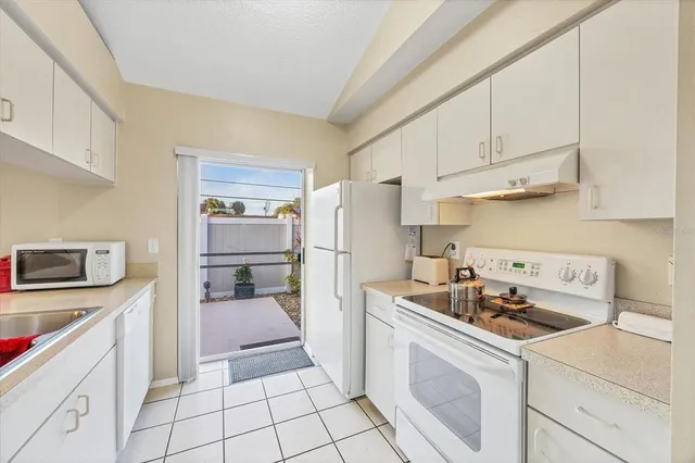 a kitchen with white cabinets and appliances