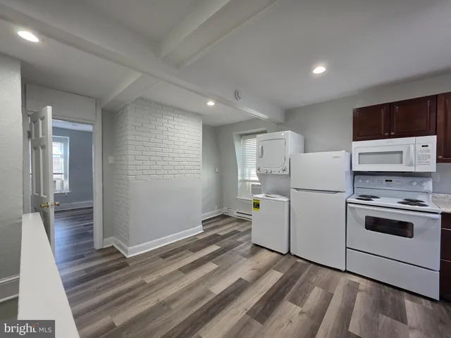 a view of kitchen with furniture and refrigerator
