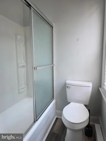 a white toilet sitting next to a bath tub