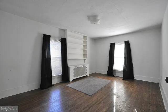 an empty room with wooden floor and closet