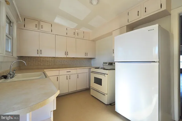 a kitchen with stainless steel appliances granite countertop a refrigerator sink and white cabinets