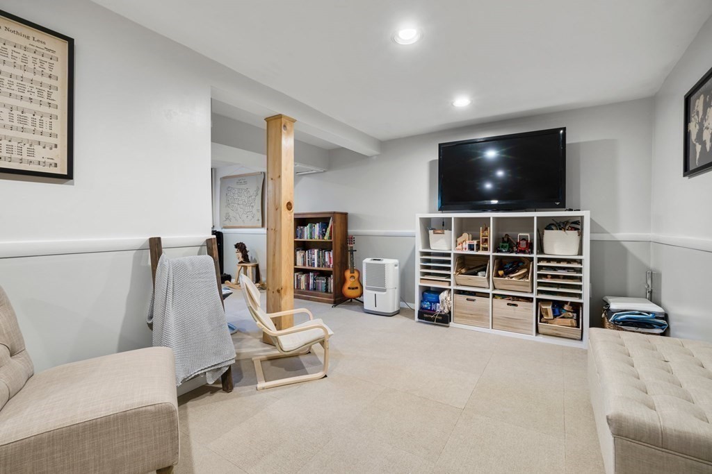 18 Corcoran Road Billerica, MA 01821 - Photo 38 of 40 a living room with furniture a flat screen tv and gym equipment